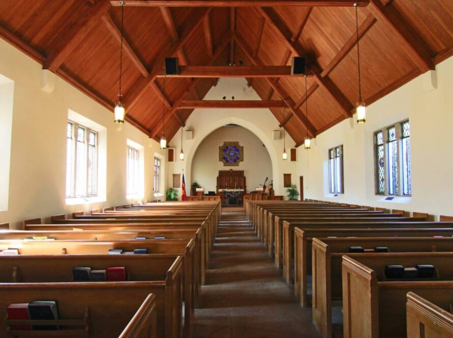 Empty church pews facing the altar.