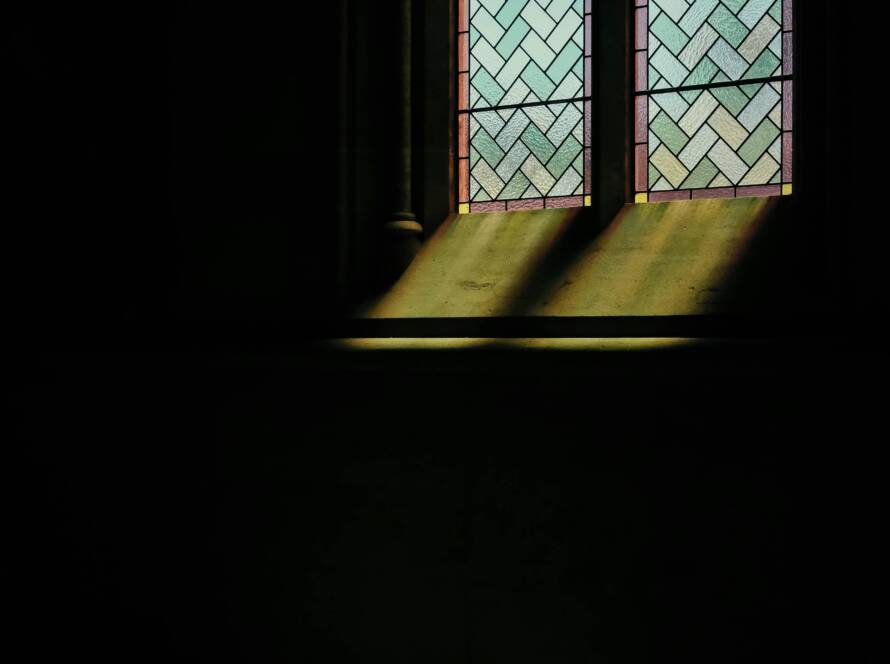 Sunlight streams through stained glass window.