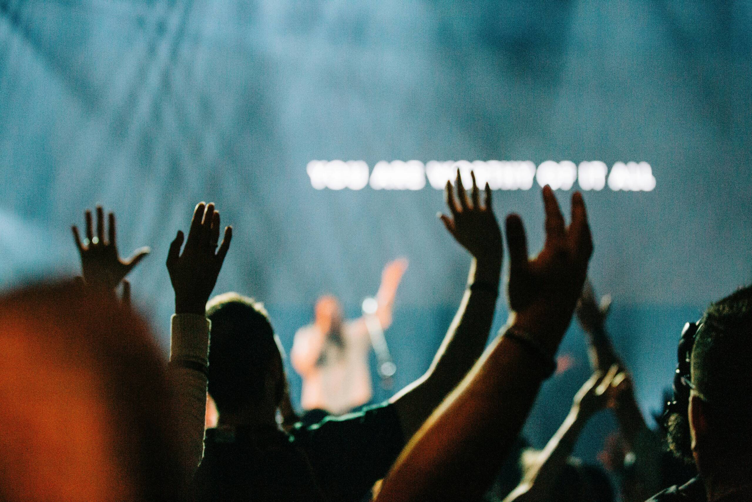 A group of people raising their hands in the air.