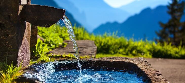 A person is drinking water from the fountain.