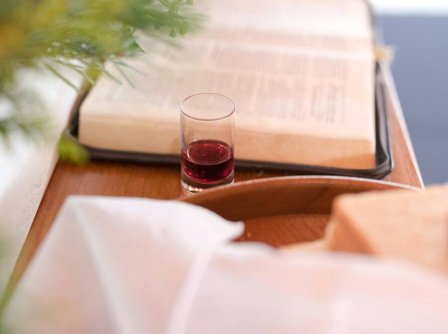 A glass of wine and some books on the table