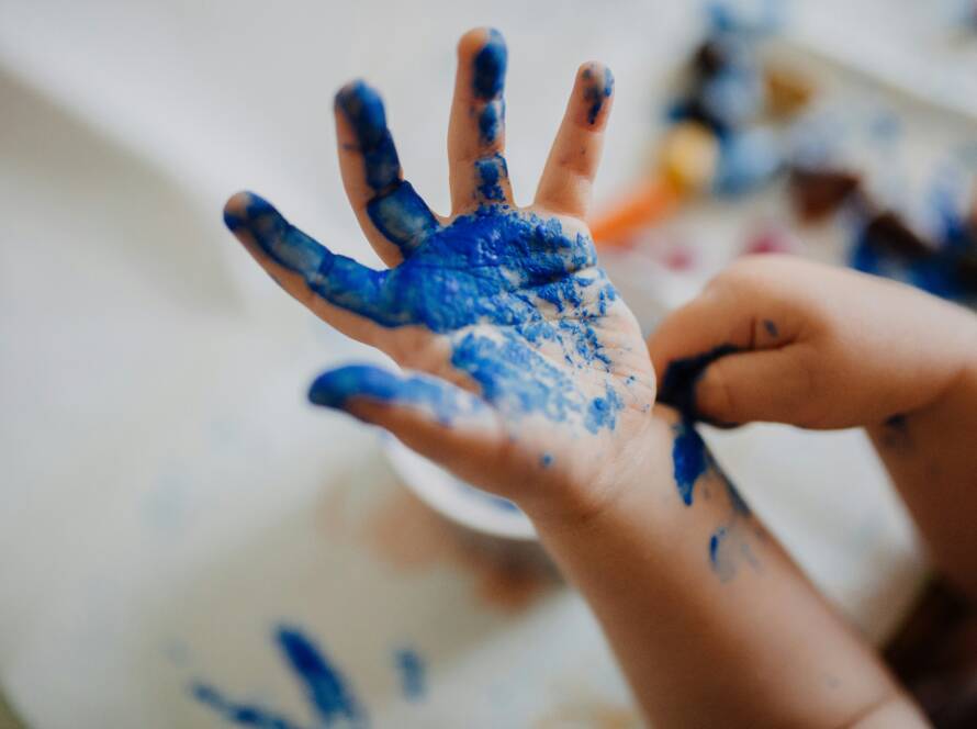 A person with blue paint on their hands.
