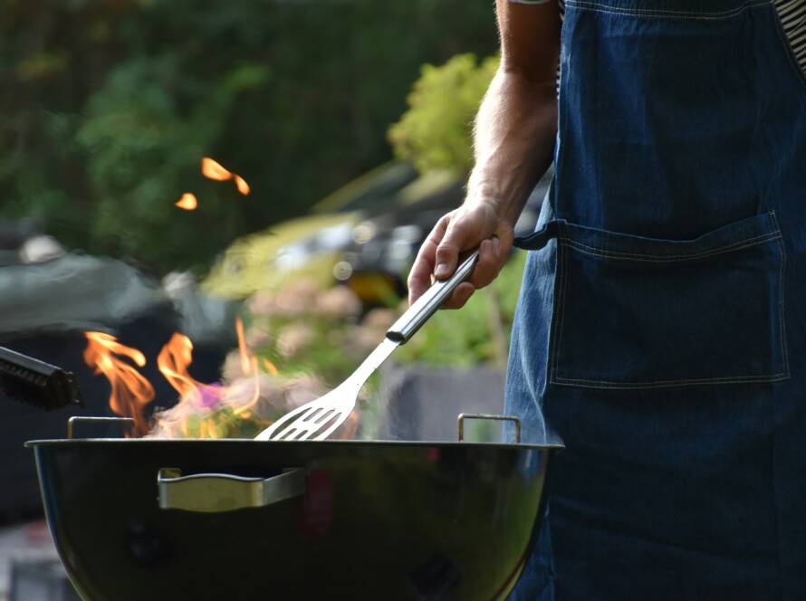 A person cooking on an outdoor grill.