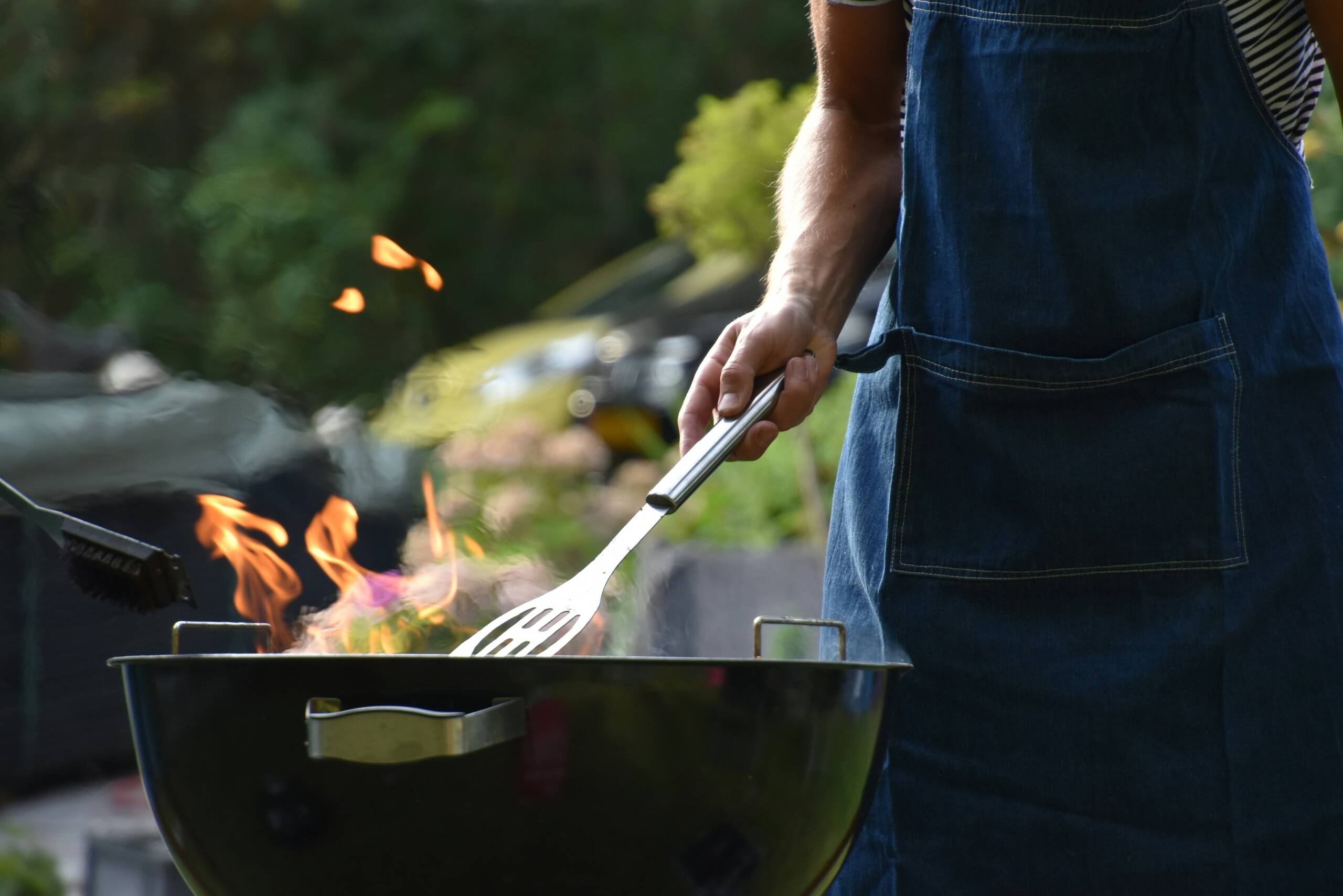 A person cooking on an outdoor grill.