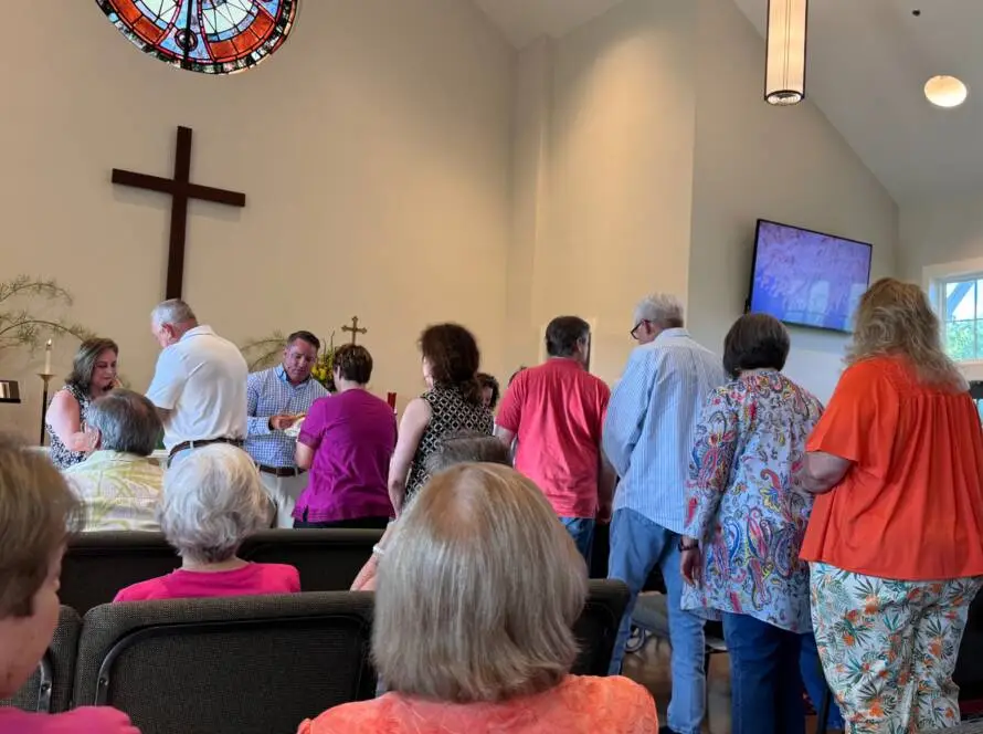 A group of people standing in front of a cross.