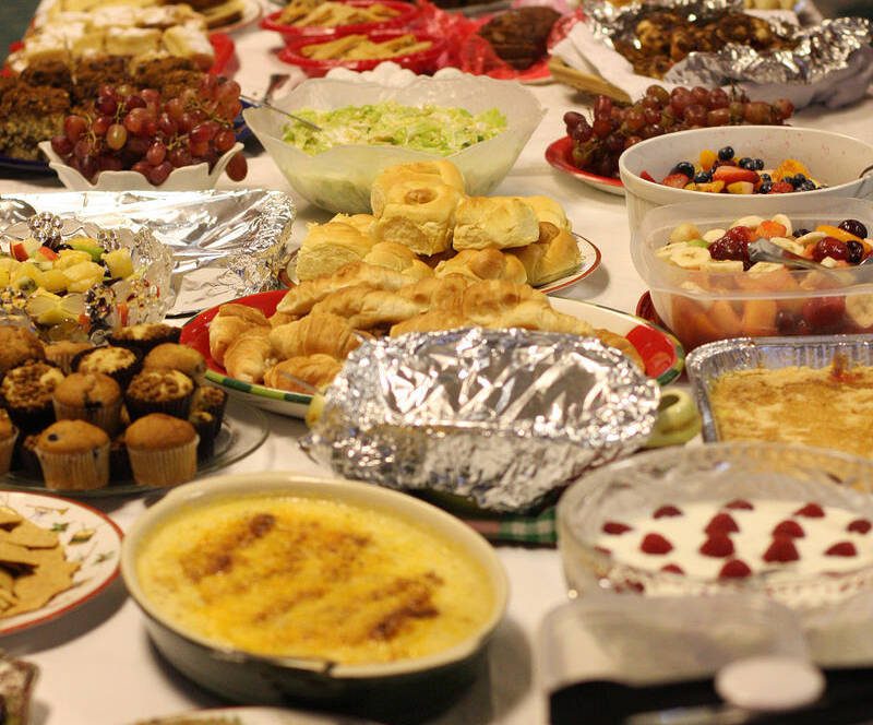 Buffet table with various dishes and desserts.