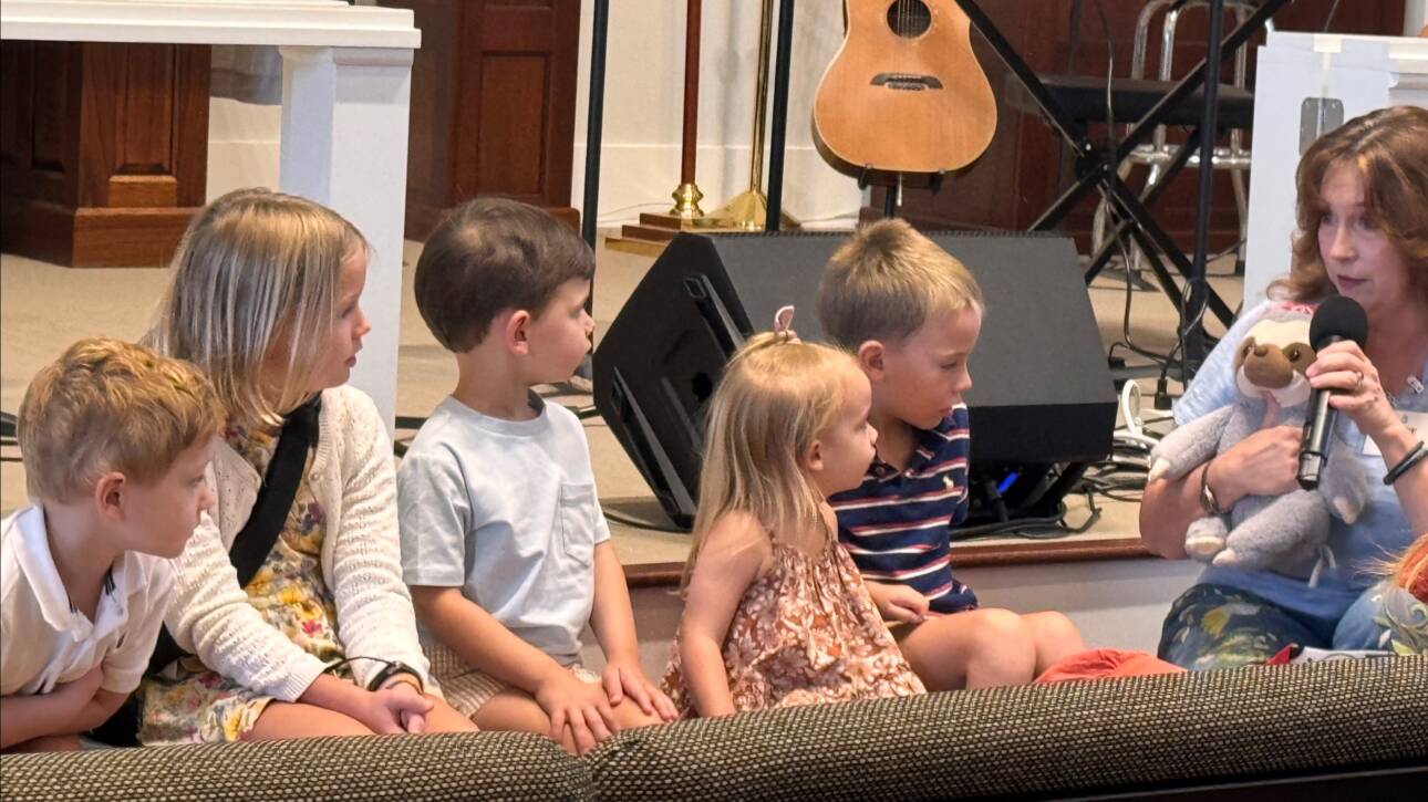 Children and woman on a stage.