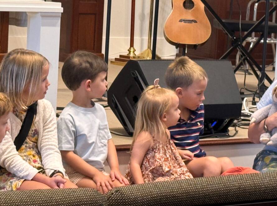 Children and woman on a stage.