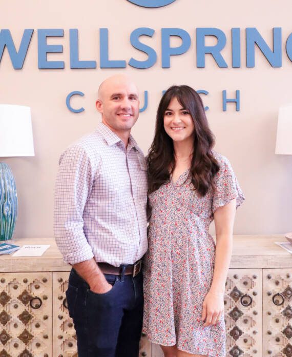 Couple smiling in front of Wellspring Church.