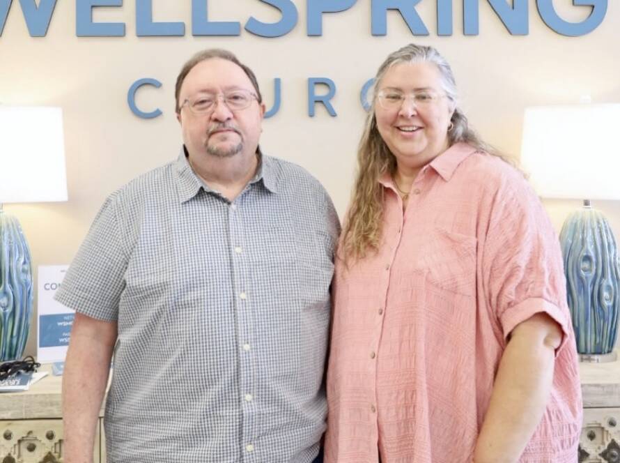 Couple standing in front of Wellspring Church.