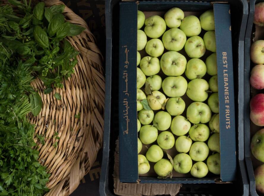 Green apples and herbs in baskets.