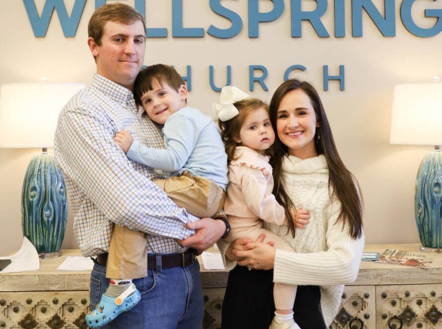 Family posing in front of Wellspring Church.