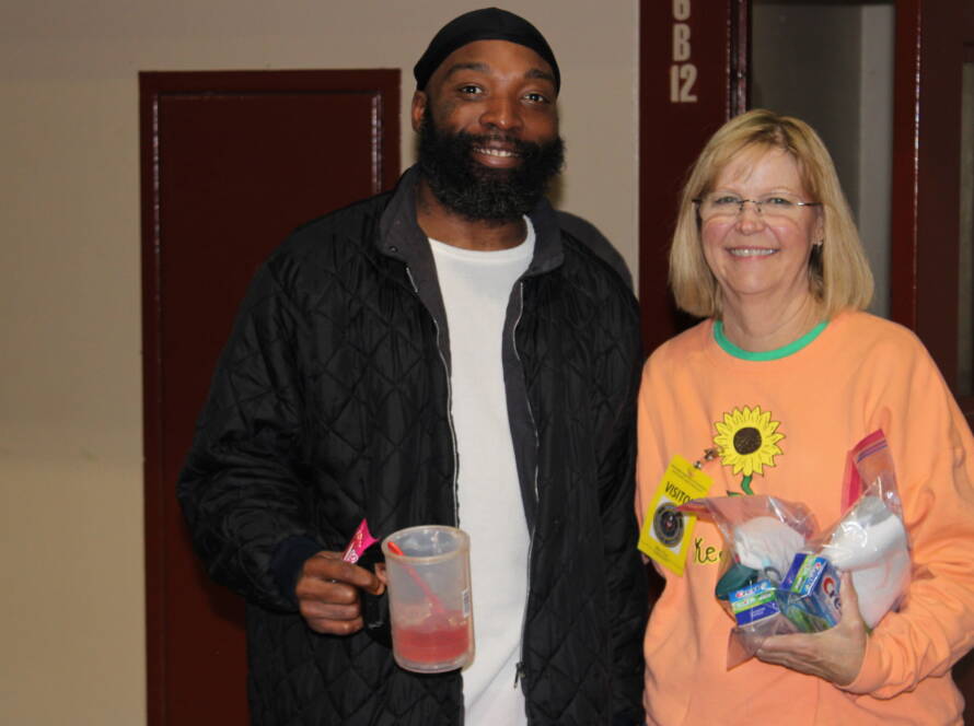 Smiling man and woman holding items indoors.