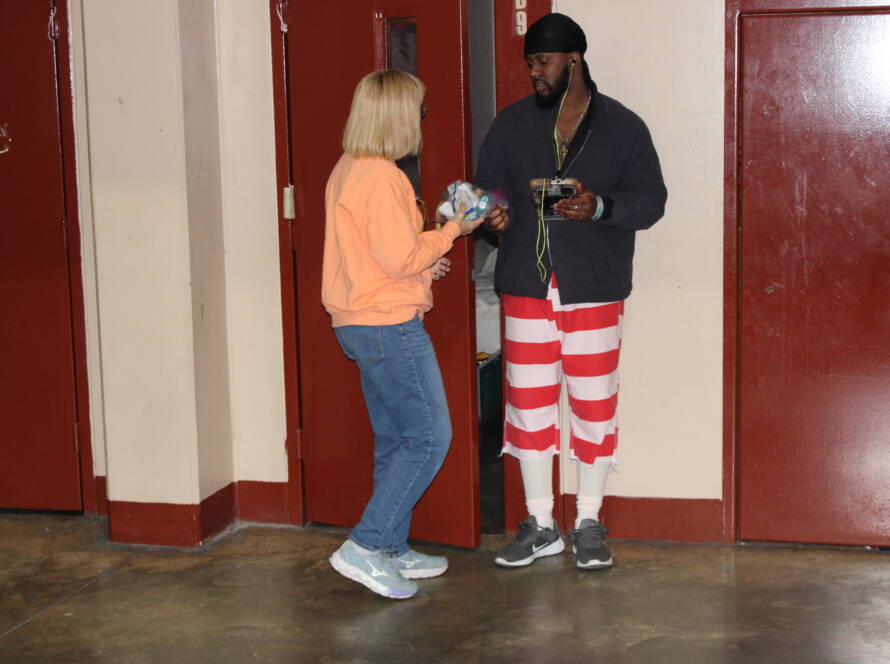 Two people standing near red doors.