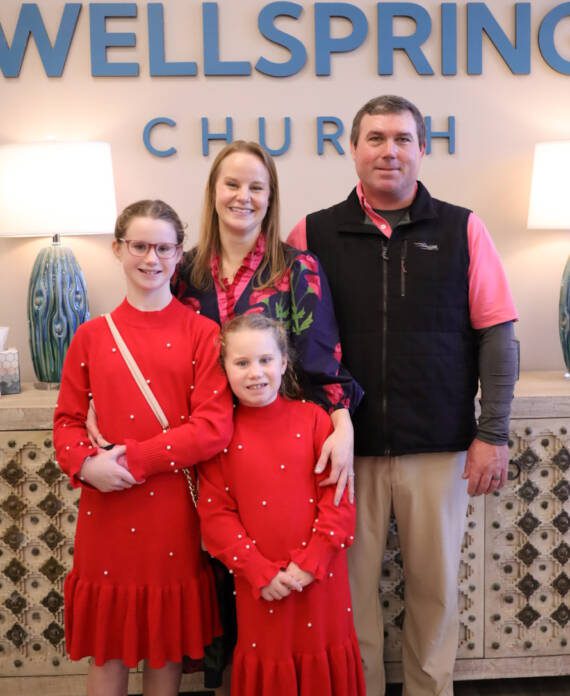 Family posing at Wellspring Church entrance.