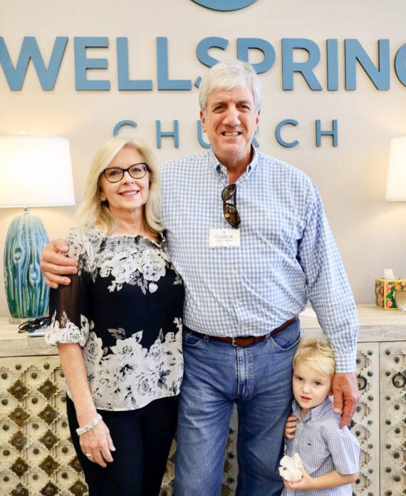 Family smiling in front of Wellspring Church.