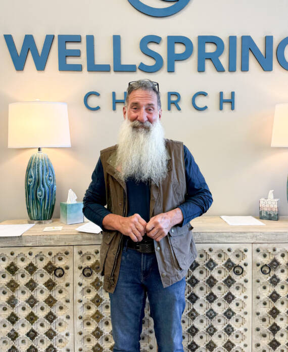 Man standing in front of Wellspring Church sign.