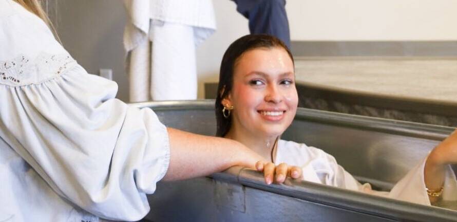 Woman smiling during a baptism ceremony.