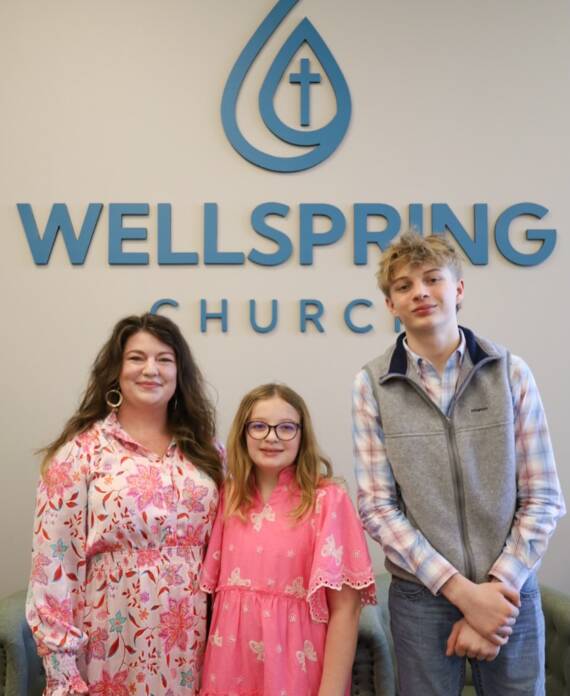 Three people in front of Wellspring Church.