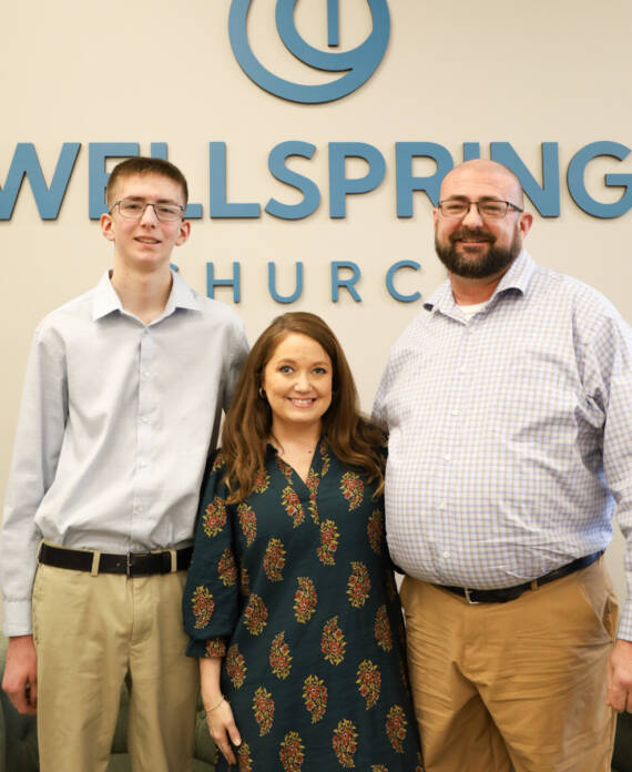 Three people standing at Wellspring Church.