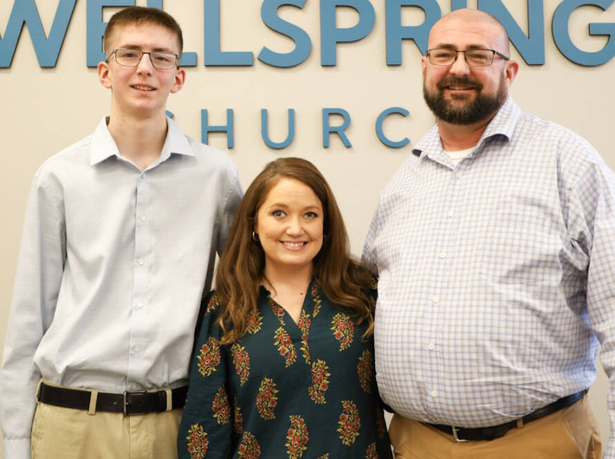 Three people standing at Wellspring Church.
