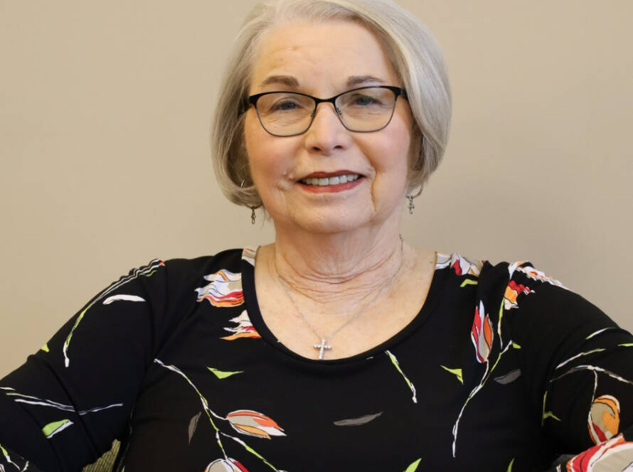 Smiling older woman with glasses, floral blouse