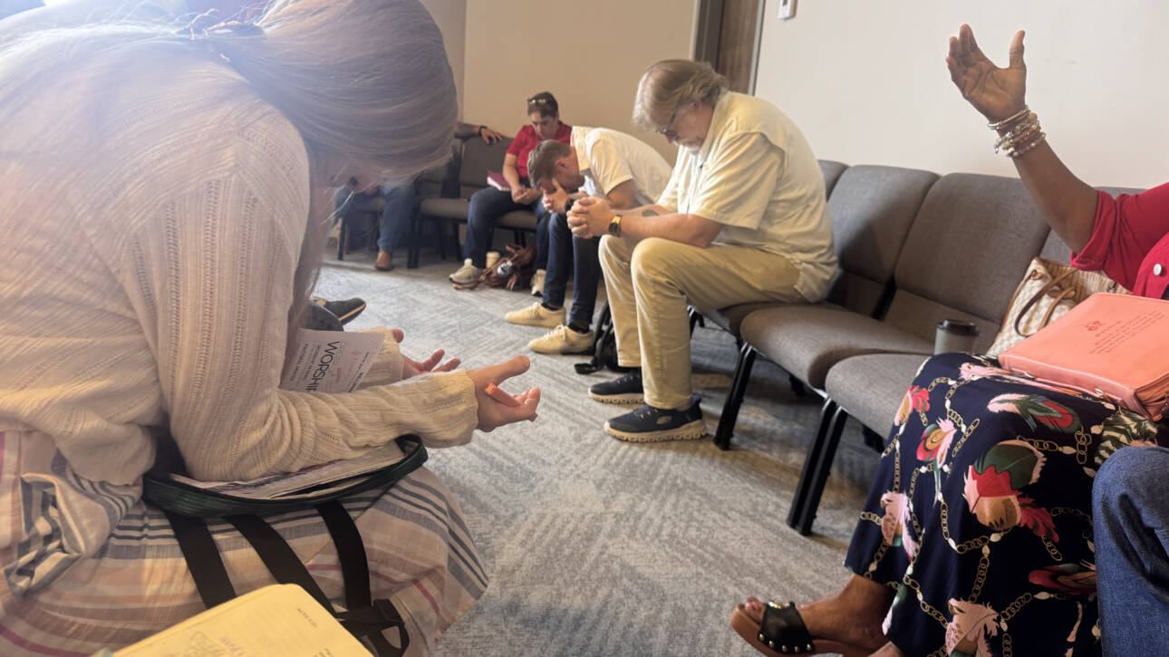Community prayer group seated in meeting room