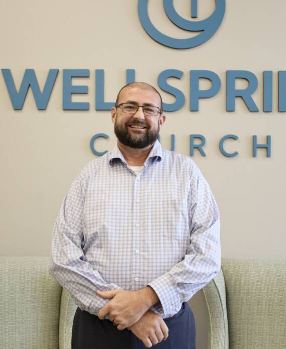 Smiling man before WellSpring Church sign